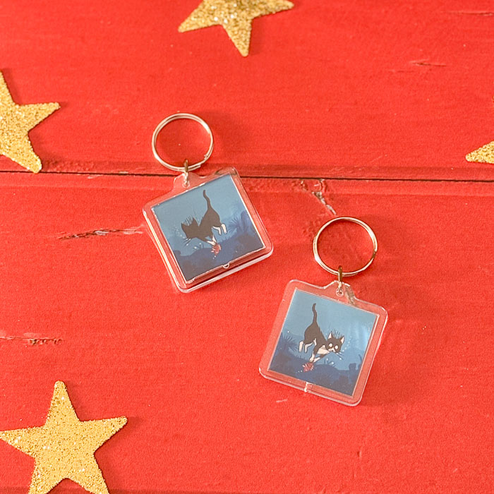 Porte-clés illustré d’un chat en tenue de plongée faisant de la pêche sous-marine, jeu de mots “poisson-chat”.