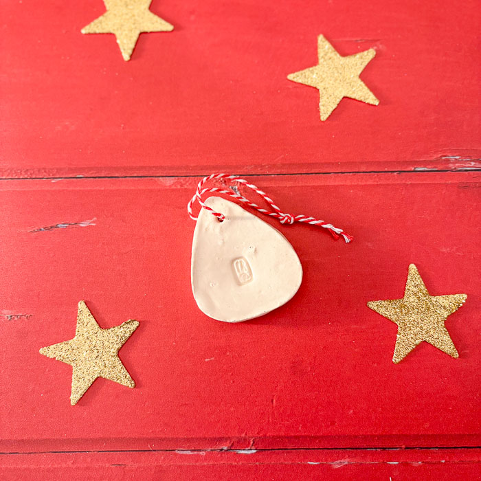 Suspension en argile en forme de petit sapin, peinte et décorée pour Noël.