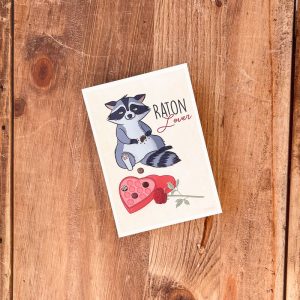 Illustration d’un petit râton laveur espiègle avec une petite bedaine, entouré de chocolats, ambiance humoristique et Saint-Valentin.